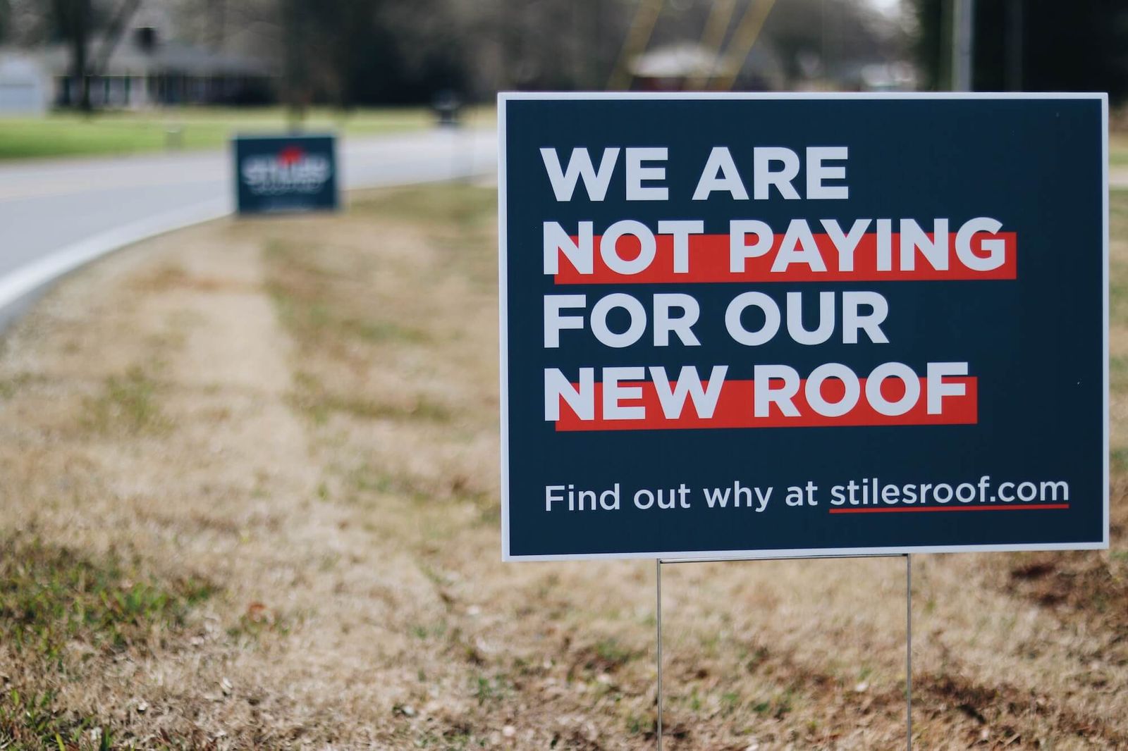 Stiles Roofing yard sign that reads We Are Not Paying For Our New Roof